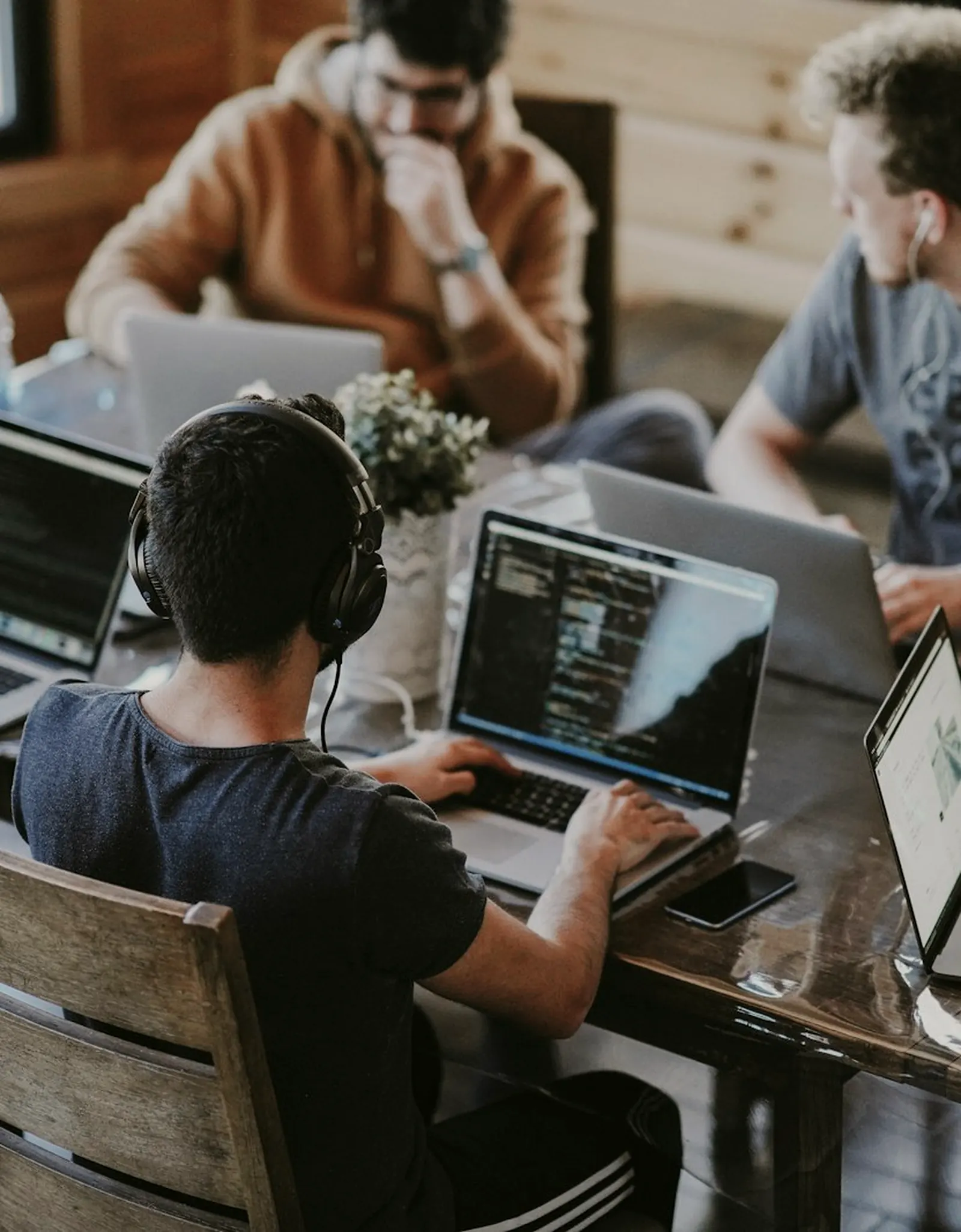 Équipe de commerciaux au travail sur leurs ordinateurs portables autour d'une table.