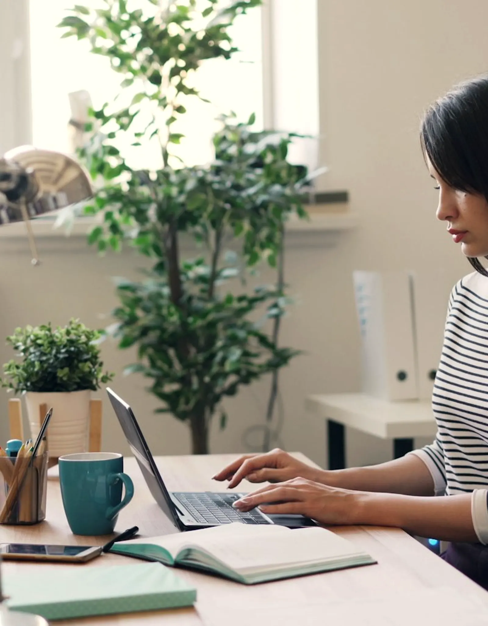 Gestionnaire au bureau, consultant son registre de suivi client sur un ordinateur portable.