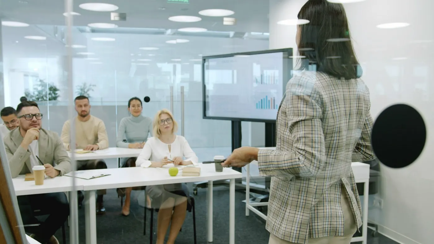 Formatrice présentant un tableau de bord à un groupe de stagiaires