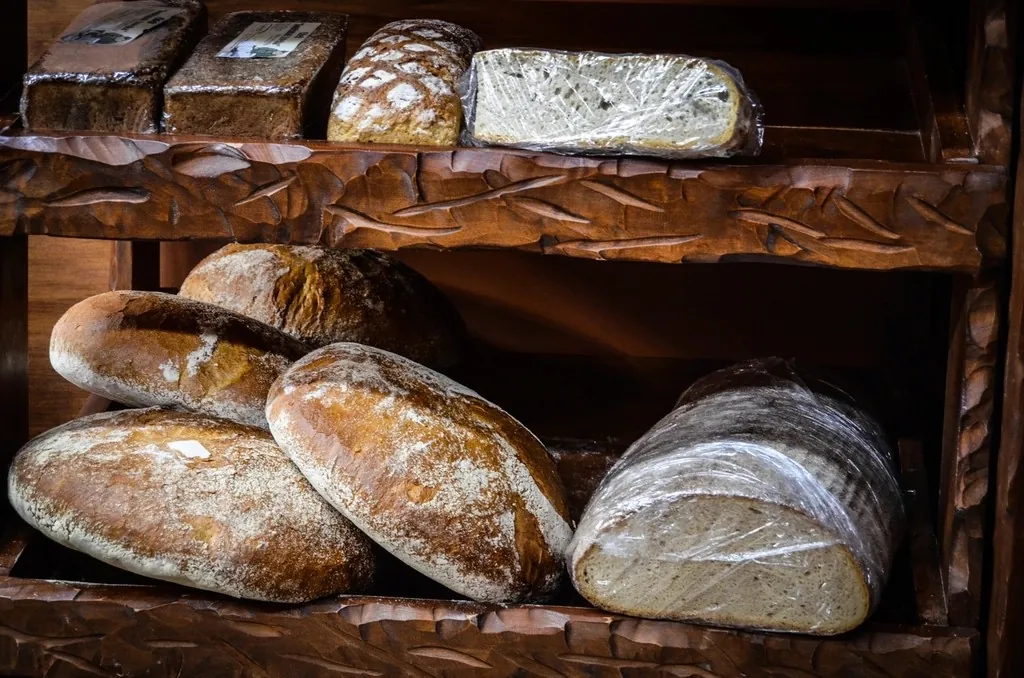 Des miches au levain rangées sur les étagères en bois de la boutique