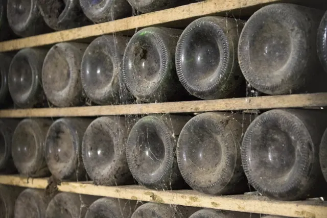 Bouteilles couchées dans une cave voûtée