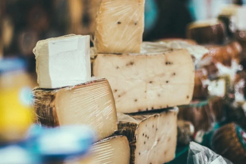 Meules de fromages affinés entamées sur l'étal, croûte naturelle