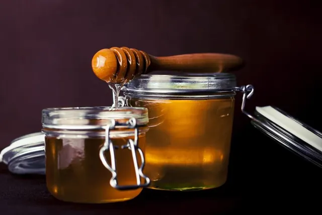 Pot de miel doré et cuillère en bois