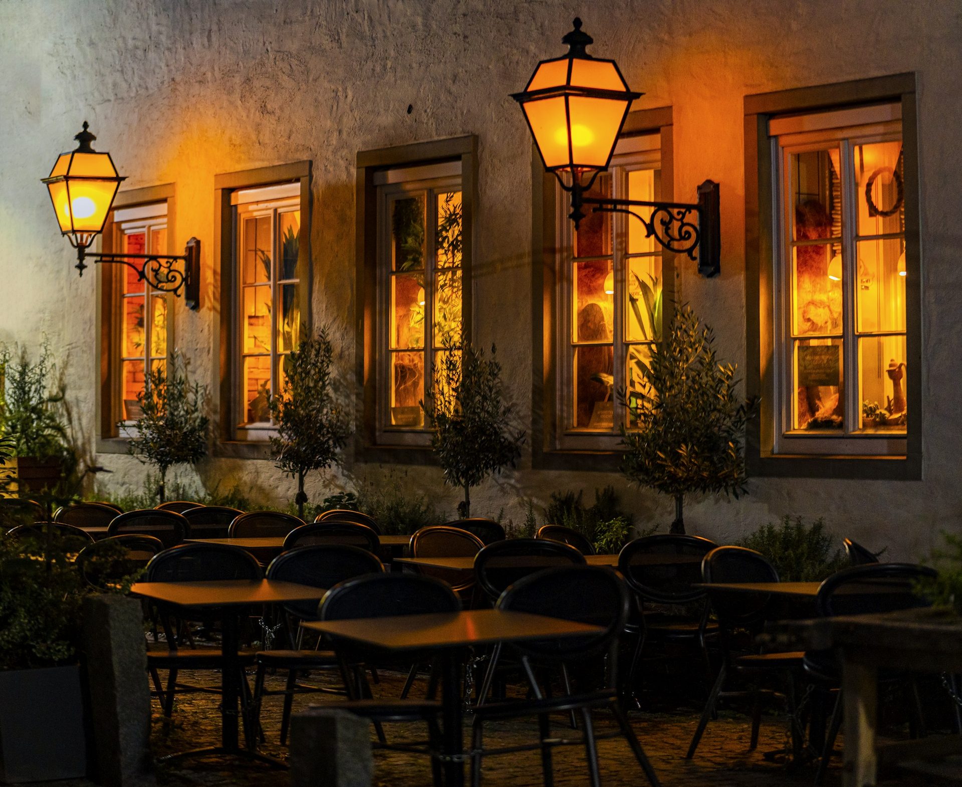 A row of tables sitting outside of a restaurant at night