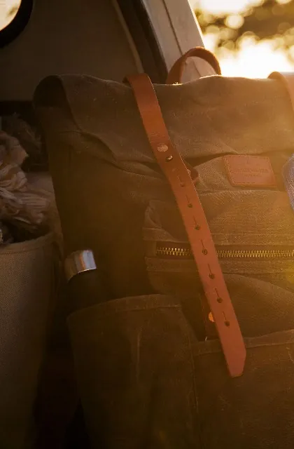 Détail d'un sac de la série 1 : sangle de cuir, rivets et fermeture éclair, au soleil couchant