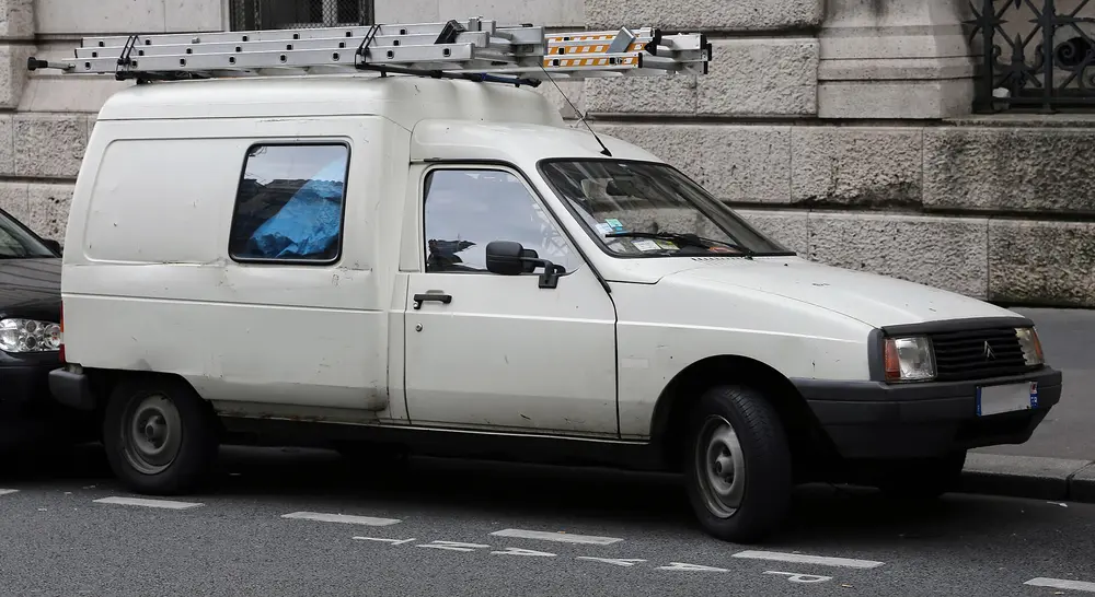 Fourgonnette utilitaire blanche garée en bord de rue