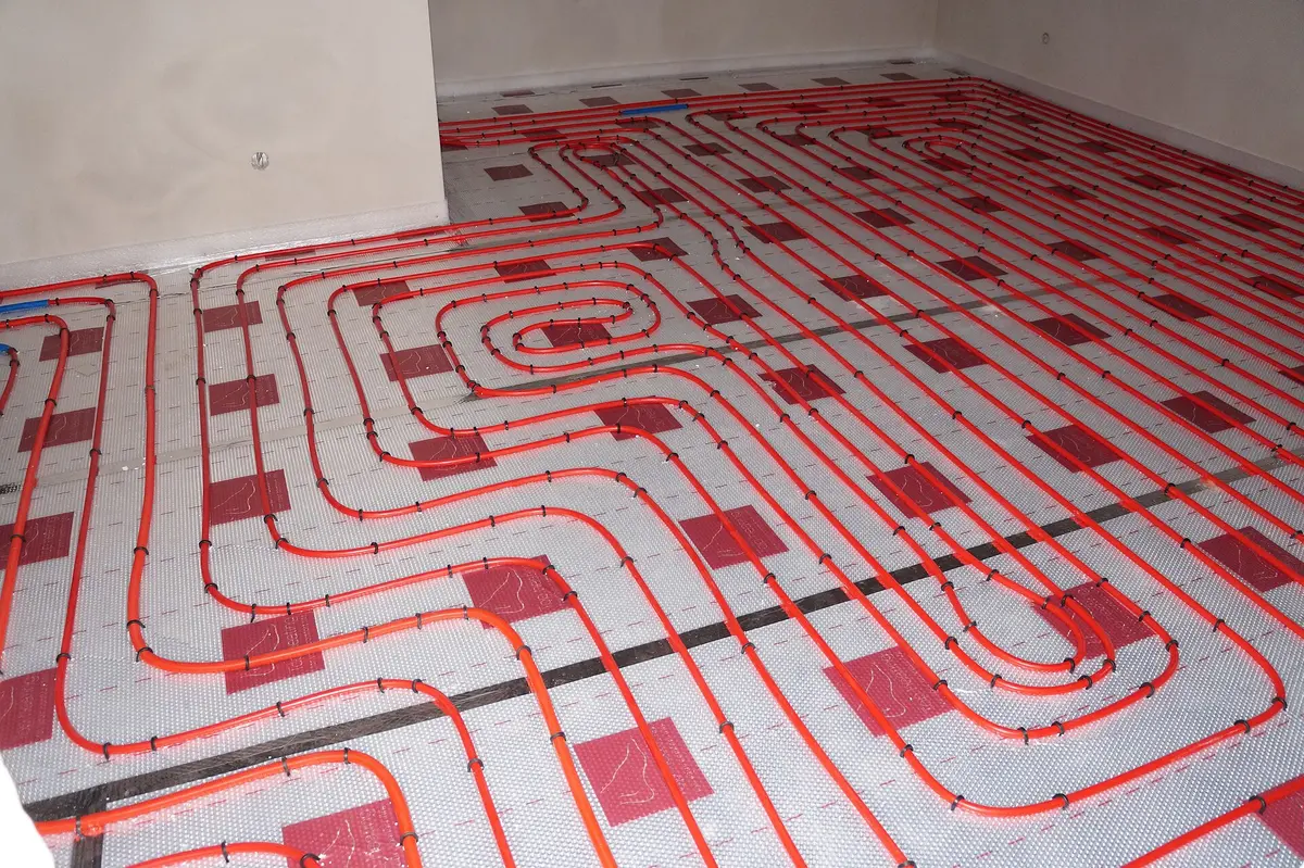 Collecteur de plancher chauffant et ses tuyaux de distribution, en cours d'installation