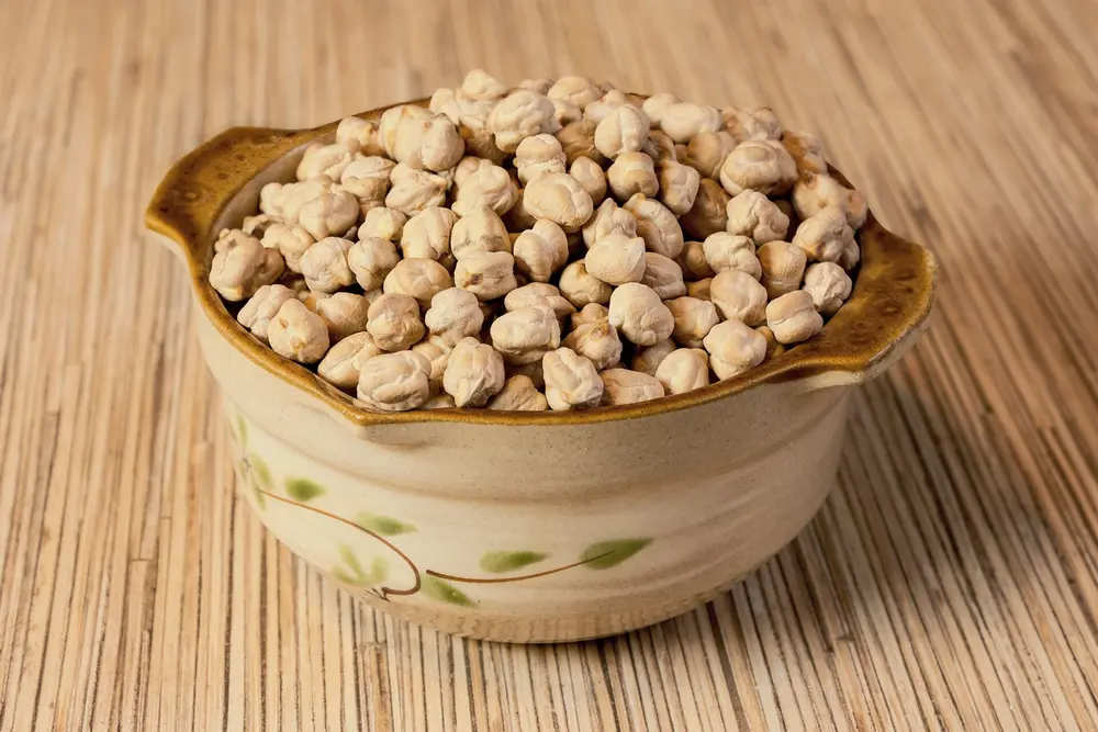 Pois chiches secs versés dans un bol en céramique