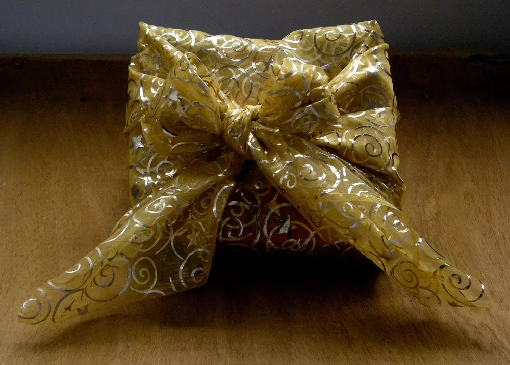 Paquet-cadeau emballé dans un tissu noué, à la façon furoshiki