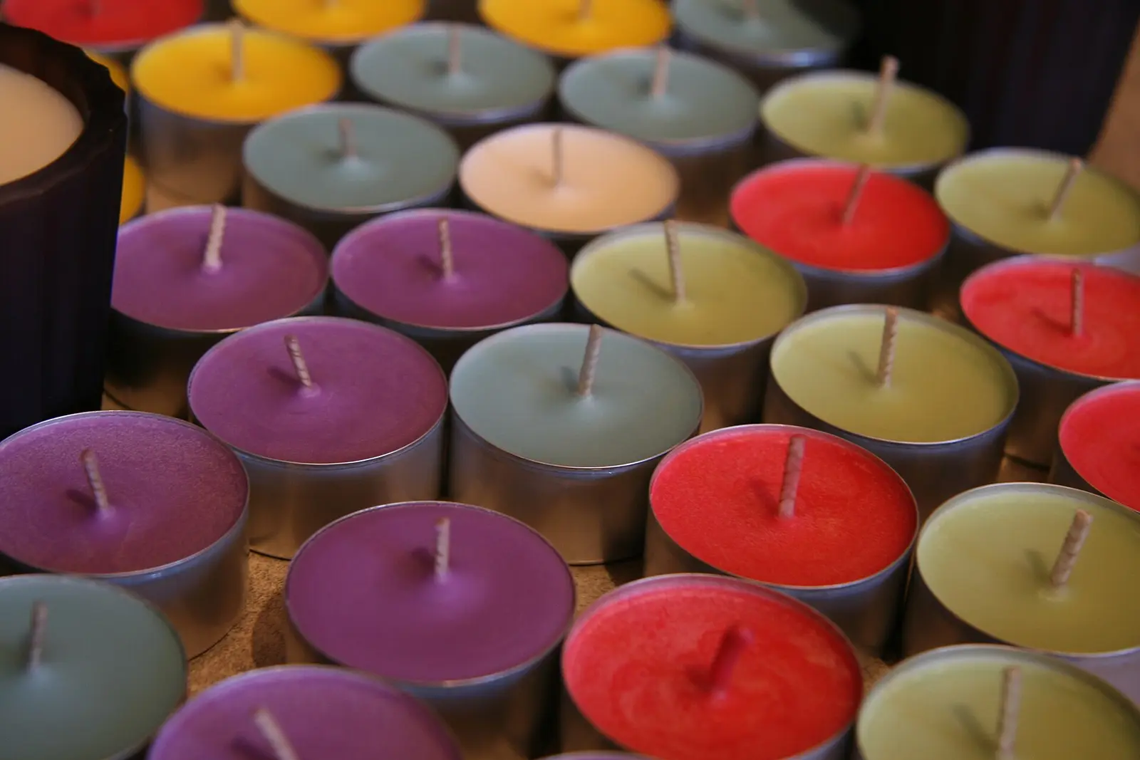 Bougies chauffe-plat de toutes les couleurs, serrées dans leurs coupelles de métal
