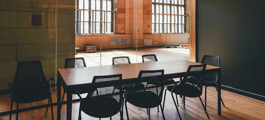 Salle de cours vide, chaises alignées face au tableau