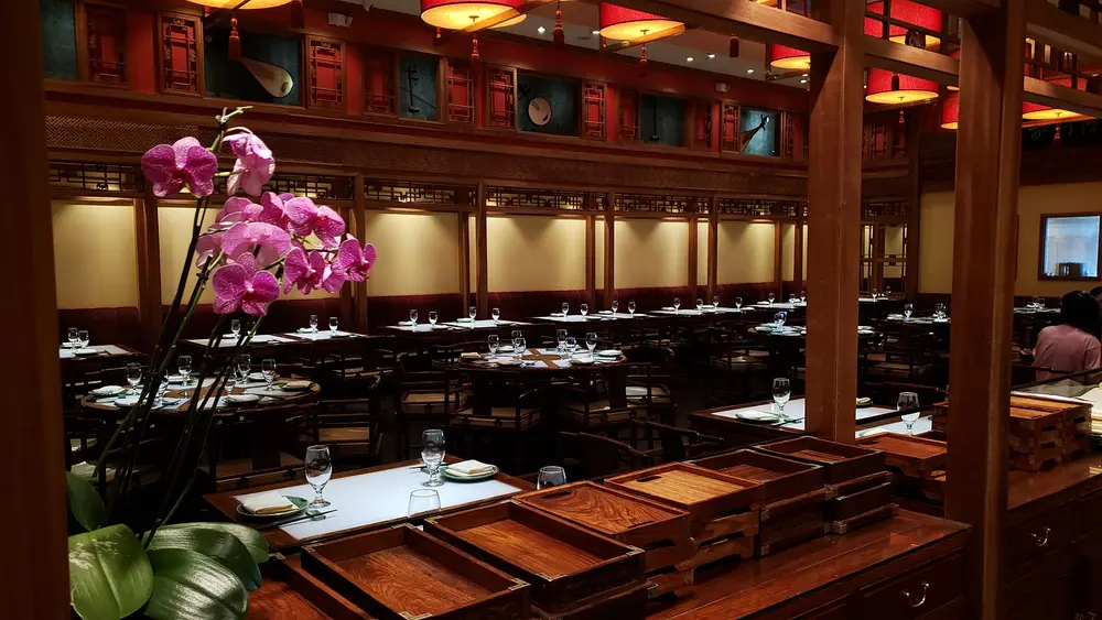Salle à manger d'un bistrot, tables dressées entre les boiseries